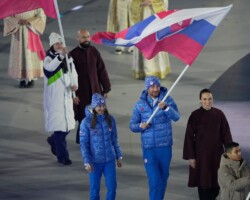 Slovakia's Rebeka Cully and Jakub Siarnik carry the Slovakian flag during the closing ceremony of the 2026 Winter Olympics, in Verona, Italy, Sunday, Feb. 22, 2026. (AP Photo/Bernat Armangue)