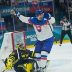 Slovakia's Pavol Regenda celebrates as his teammate Martin Gernat scores his side's second goal during a preliminary round match of men's ice hockey between Sweden and Slovakia at the 2026 Winter Olympics, in Milan, Italy, Saturday, Feb. 14, 2026. (AP Photo/Petr David Josek)