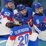 Slovakia's Juraj Slafkovsky, center, celebrates after scoring his side's opening goal during a preliminary round match of men's ice hockey between Sweden and Slovakia at the 2026 Winter Olympics, in Milan, Italy, Saturday, Feb. 14, 2026. (AP Photo/Petr David Josek)