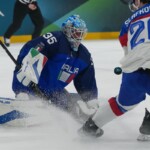 Italy's goalkeeper Davide Fadani (35) makes a save against Slovakia's Juraj Slafkovsky (20) during a preliminary round match of men's ice hockey between Italy and Slovakia at the 2026 Winter Olympics, in Milan, Italy, Friday, Feb. 13, 2026. (AP Photo/Carolyn Kaster)